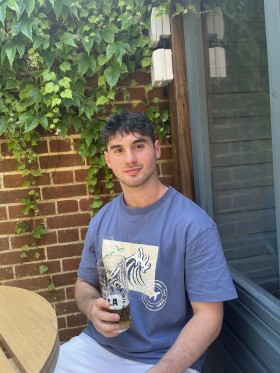 Dan Aspiazu sitting in garden holding a drink