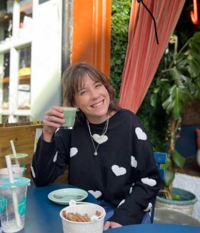 photo of Lucy sitting holding a cup